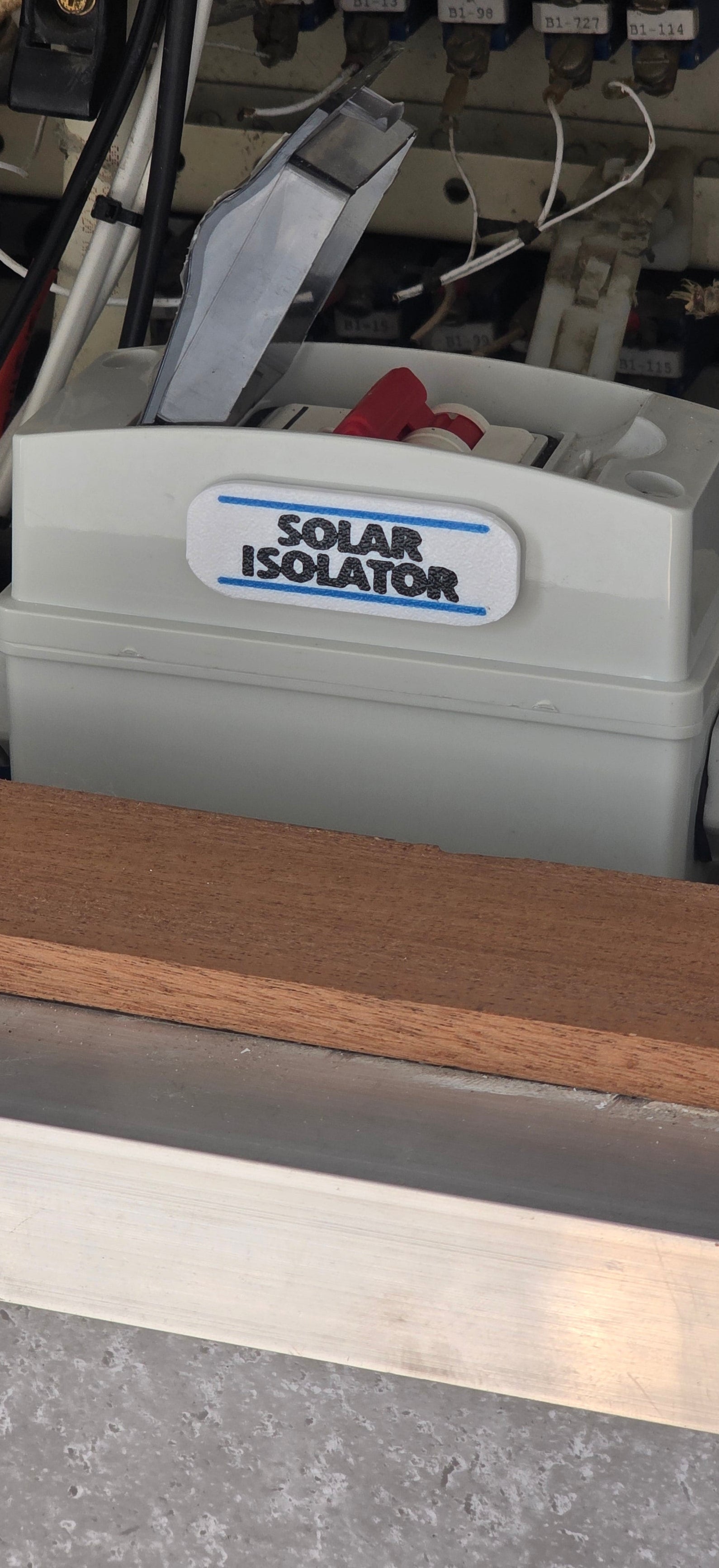 Mechanical component with 'Solar Isolator' label on a blurred background solar plaque sticker placard