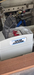 White electrical component labeled 'Solar Isolator' on a mechanical background