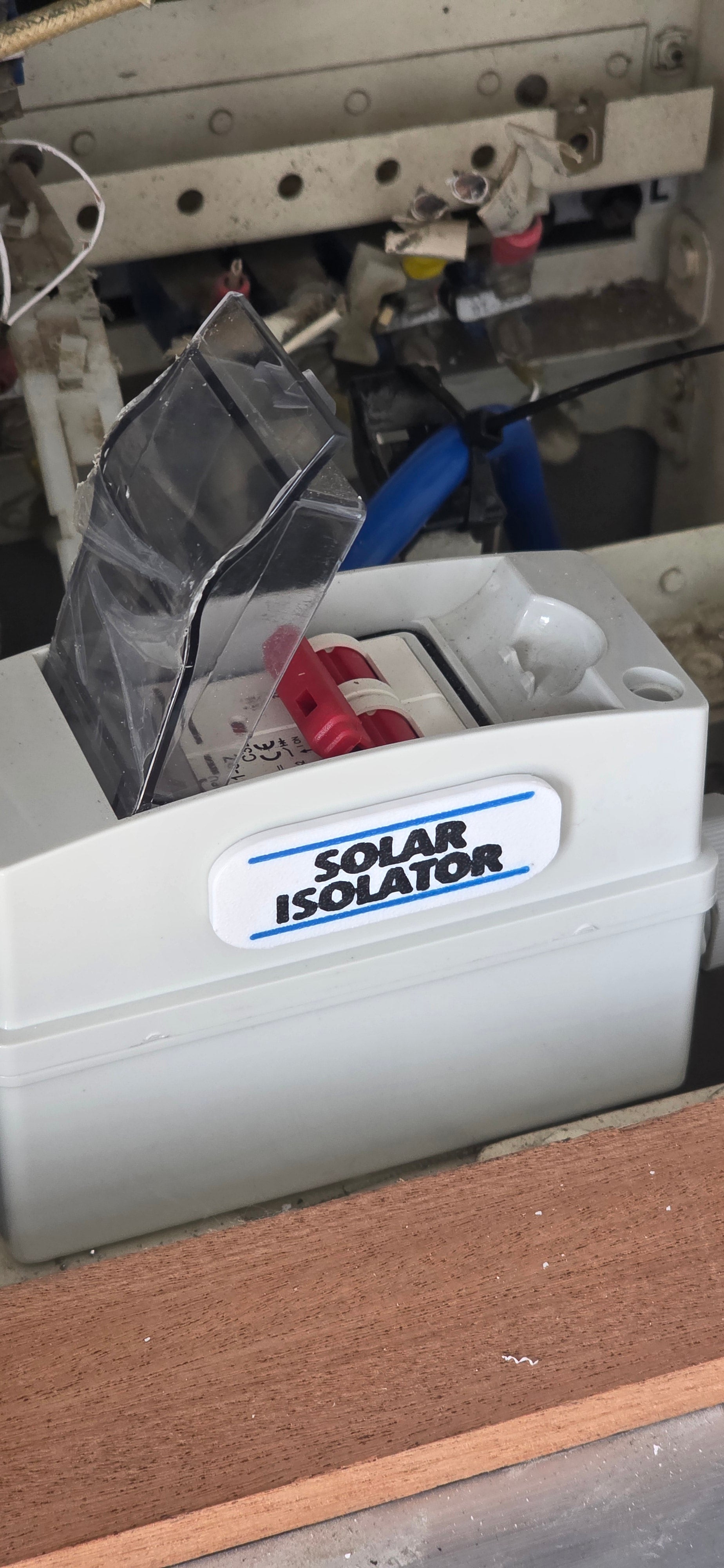 White electrical component labeled 'Solar Isolator' on a mechanical background